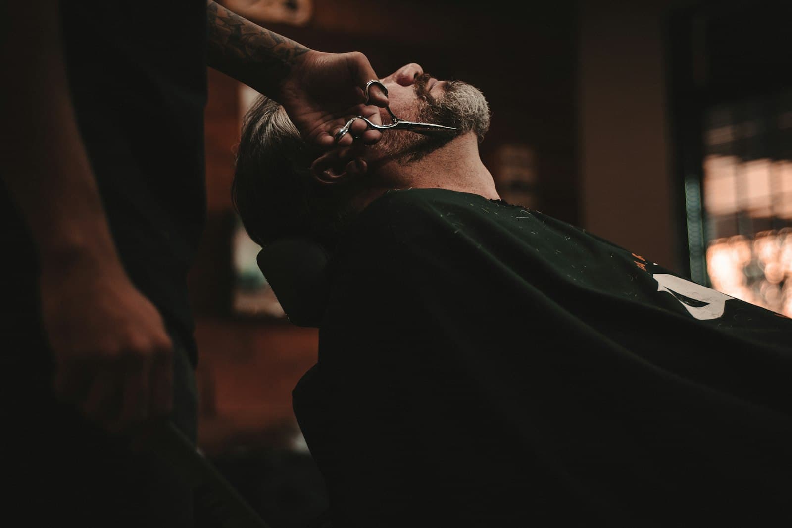 Barbero trabajando en una barbería con luz cálida