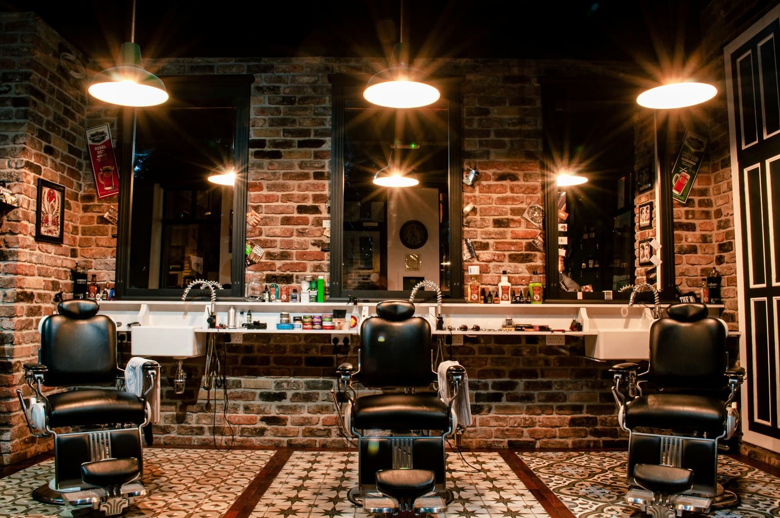 Interior de una barbería con ladrillo visto y lámparas cálidas